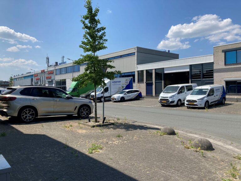 Auto's staan op een parkeerplaats op een redelijk vergrijst bedrijventerrein