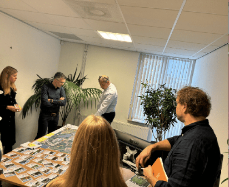 Mensen staan in een kantoorruimte en zijn in gesprek tijdens een workshop