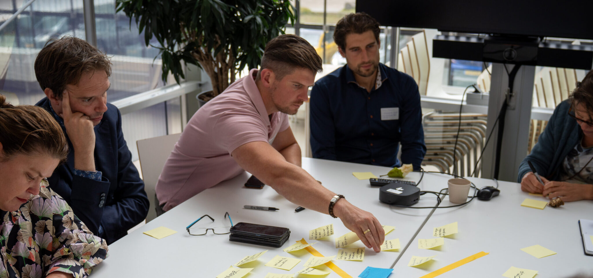 Mensen plakken post-its op een tafel voor een vergadering