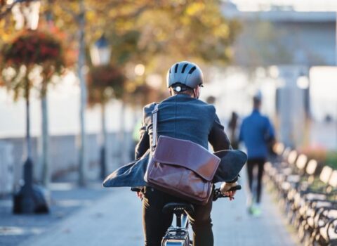 man met help en gekleed in pak op de fiets naar werk